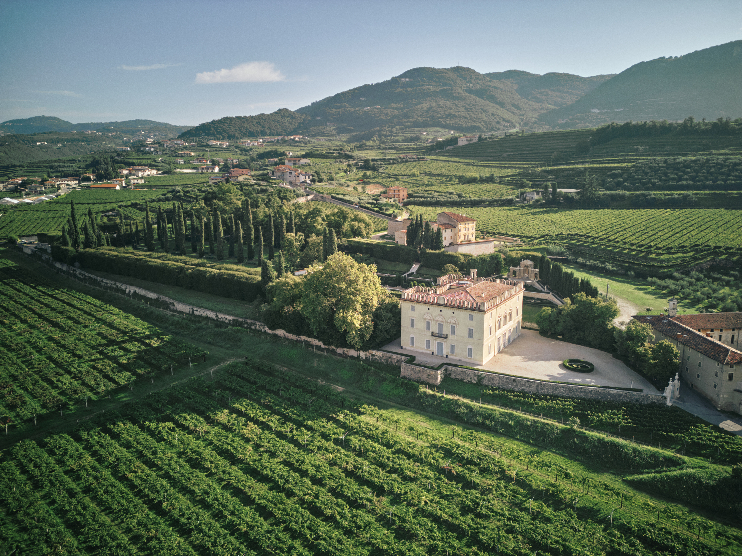 Veduta aerea di Villa Rizzardi e del Giardino di Pojega, circondati dai vigneti e dalle colline della Valpolicella.