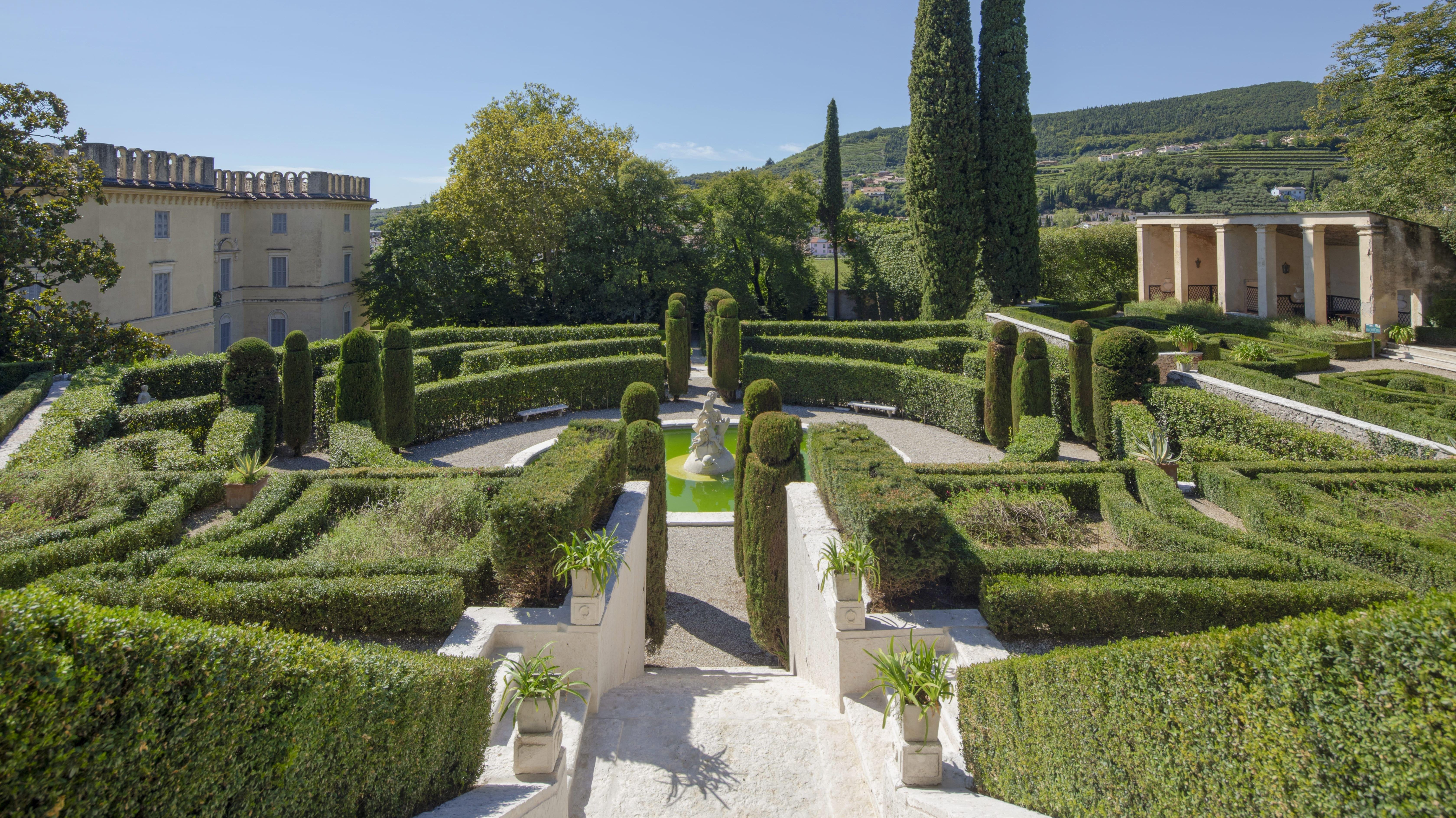 View of the Italian formal garden at Pojega Garden from the Neptune Staircase, featuring the central fountain and ornamental pond.